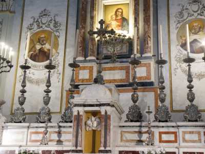 Un�icona centrale della Madonna col Bambino, illuminata da un altro candelabro a sette bracci, � circondata sui lati da icone di santi all'interno di medaglioni